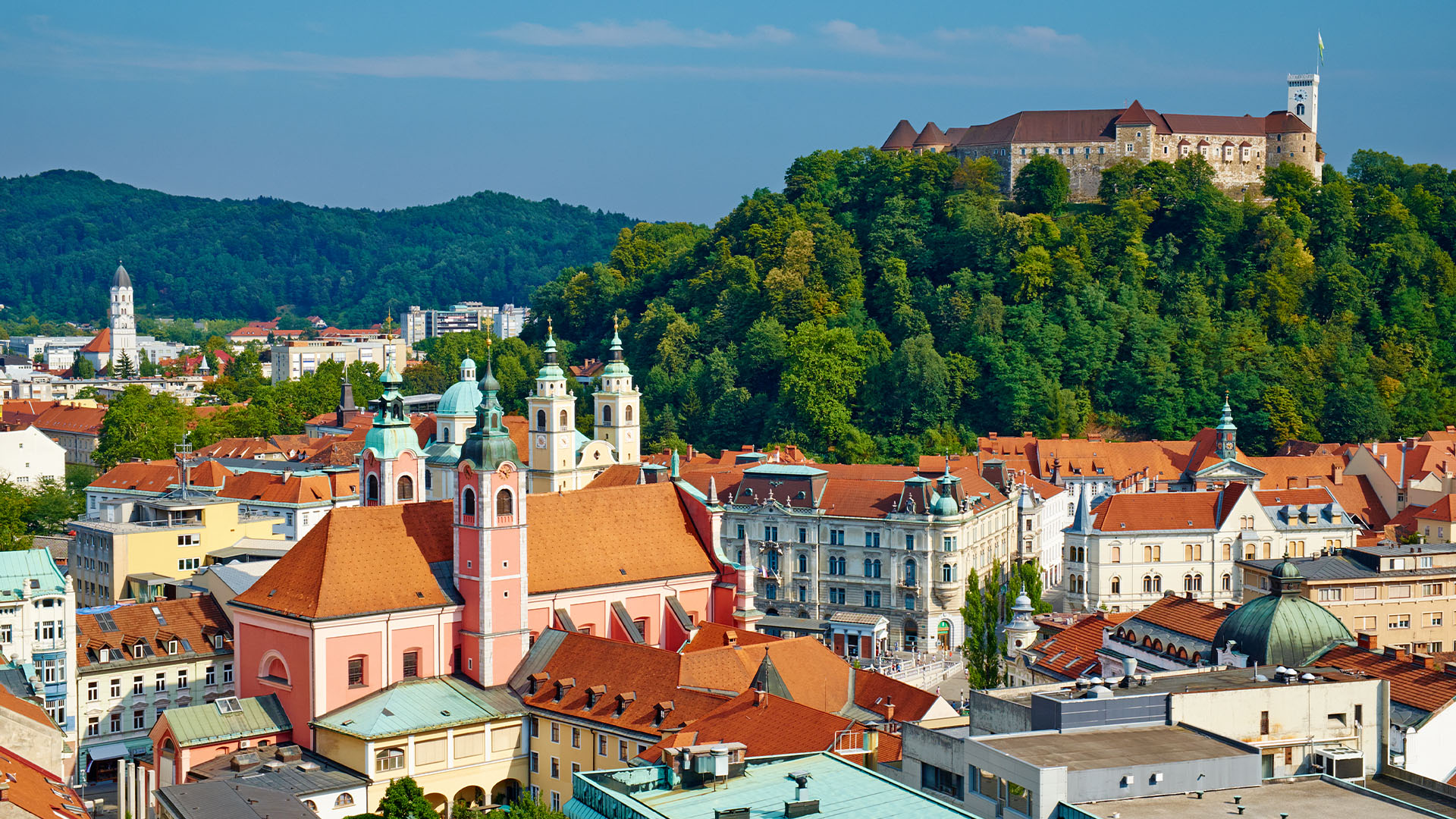 Colourful town buildings below a hilltop castle