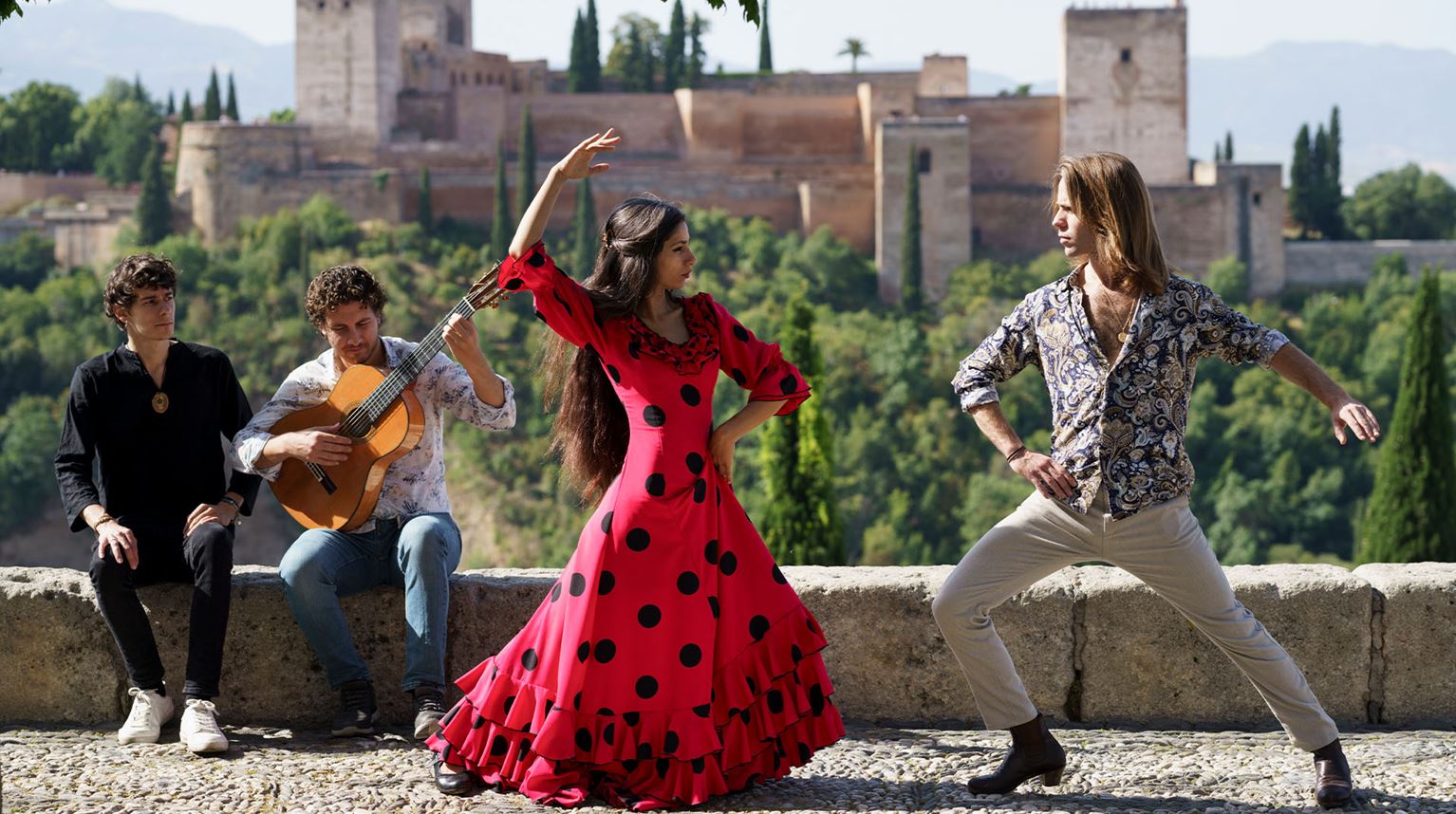 Flamenco dancers and musicians performing outdoors.