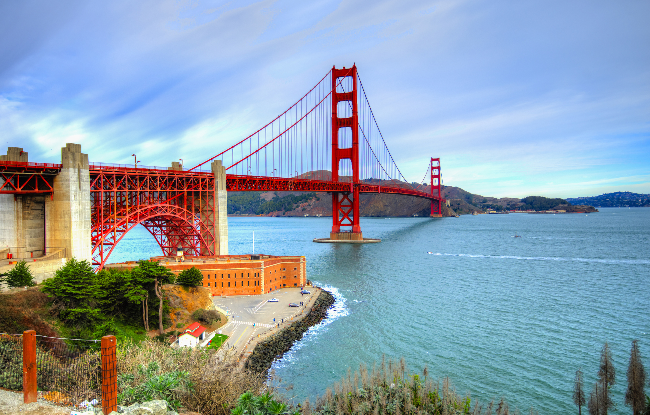 View of the Golden Gate Bridge over water and distant hills, San Francisco and Marin County near Sausalito, CA, US.