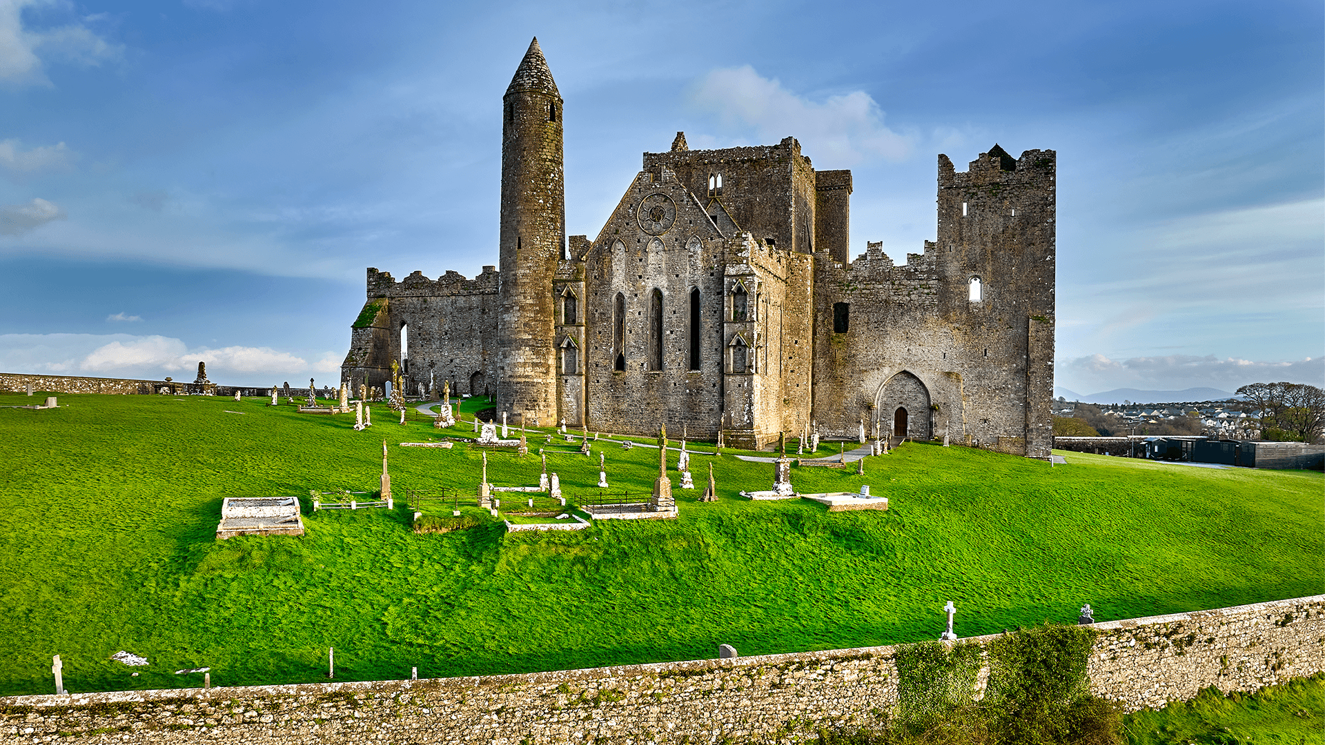 Medieval stone abbey ruins on a green hillside