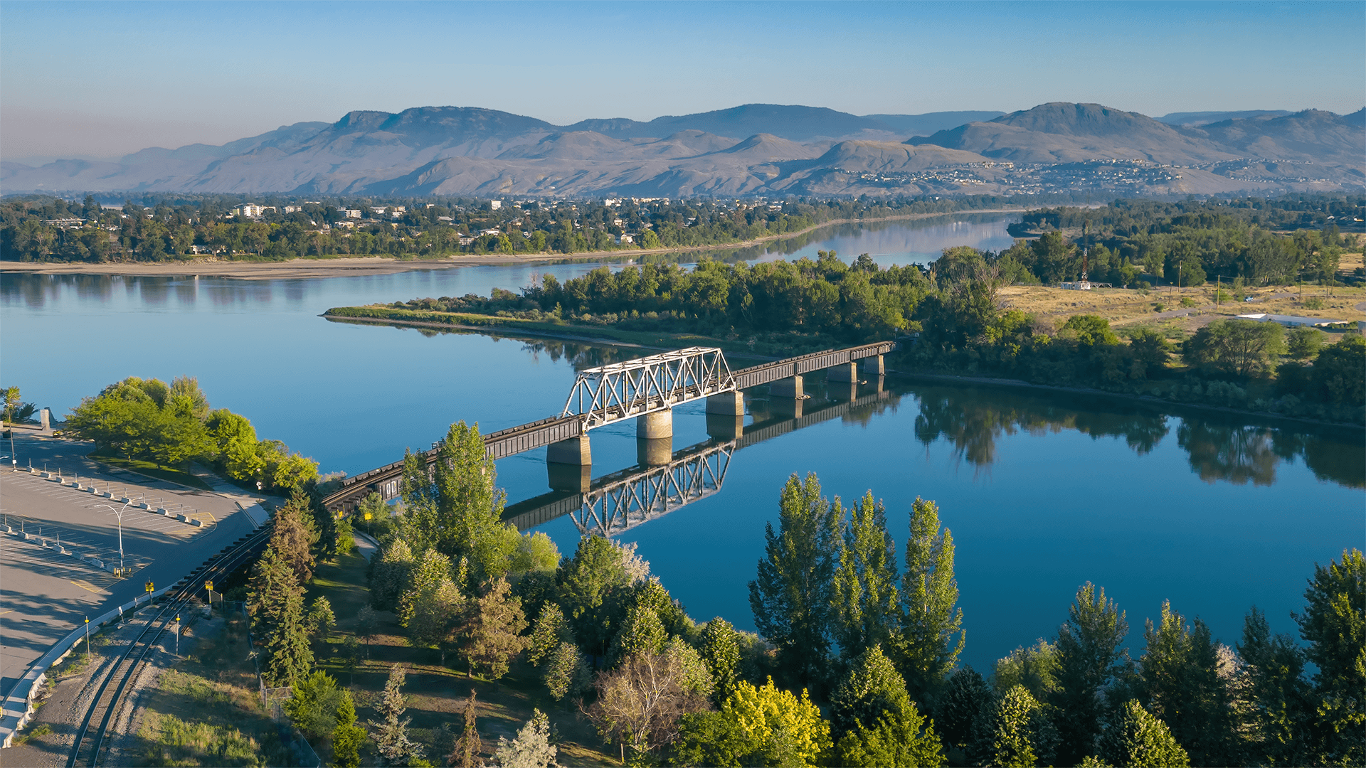 View of a bridge over a river with mountains nearby