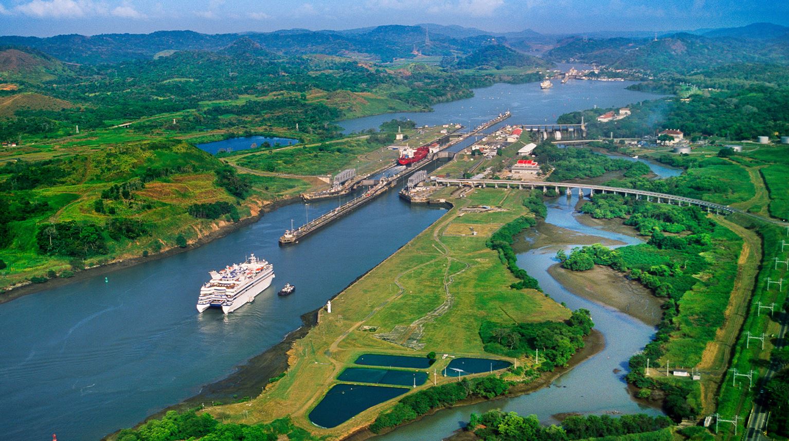 Aerial view of cruise ship on river in green landscape