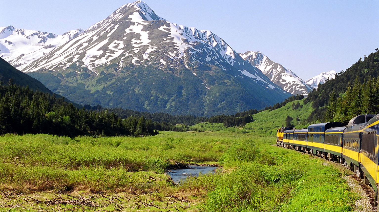 Panorama of a train traveling through the snow capped mountains, Denali National Park, Alaska