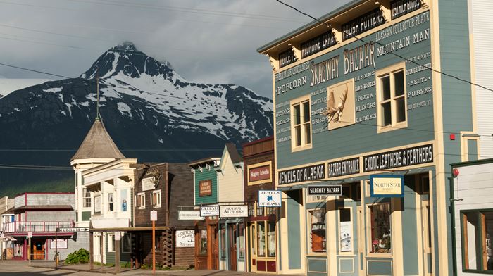 View of old small houses and shops with a mountain in the background.