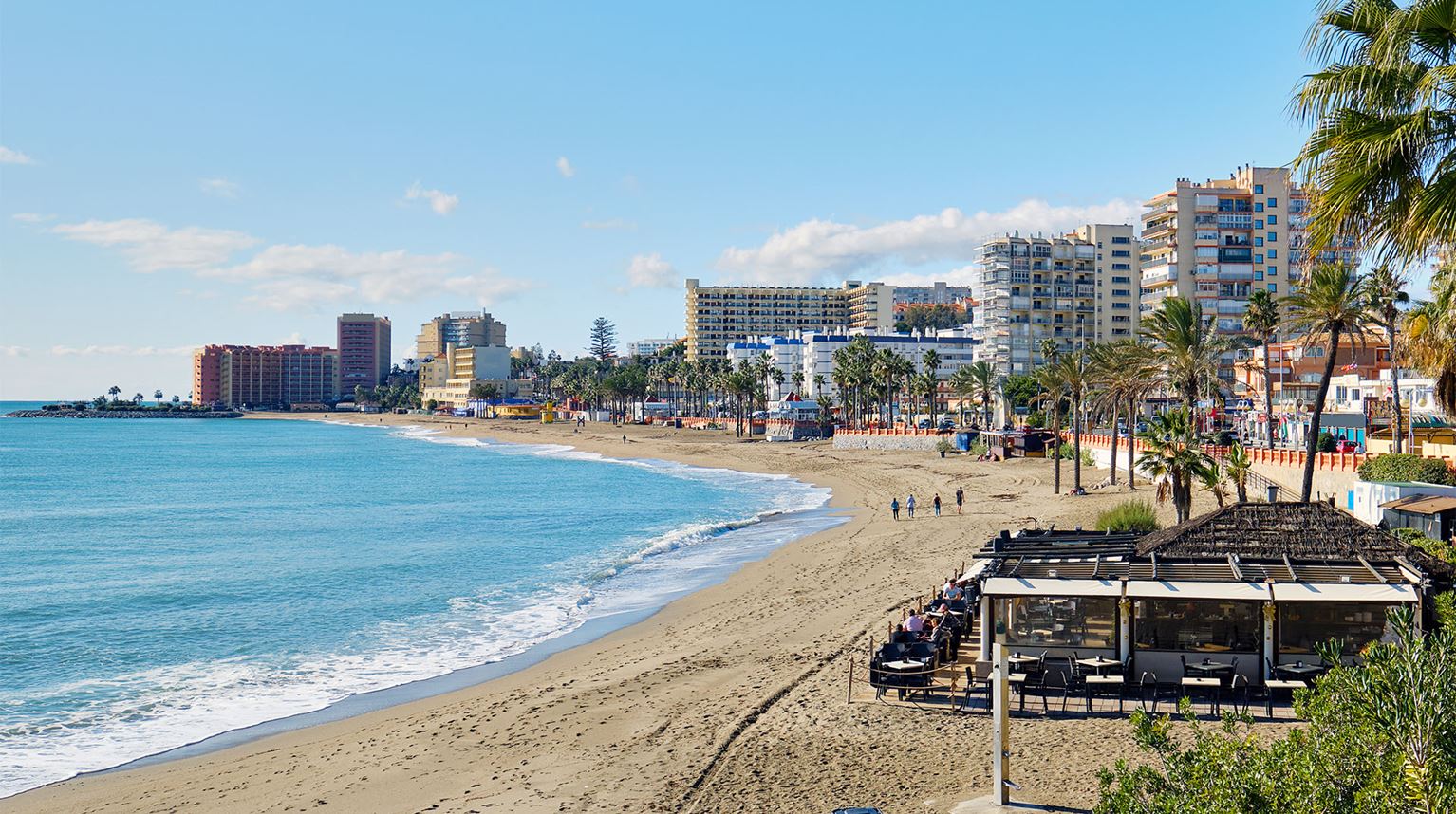 Benalmadena Beach next to a row of apartment buildings.