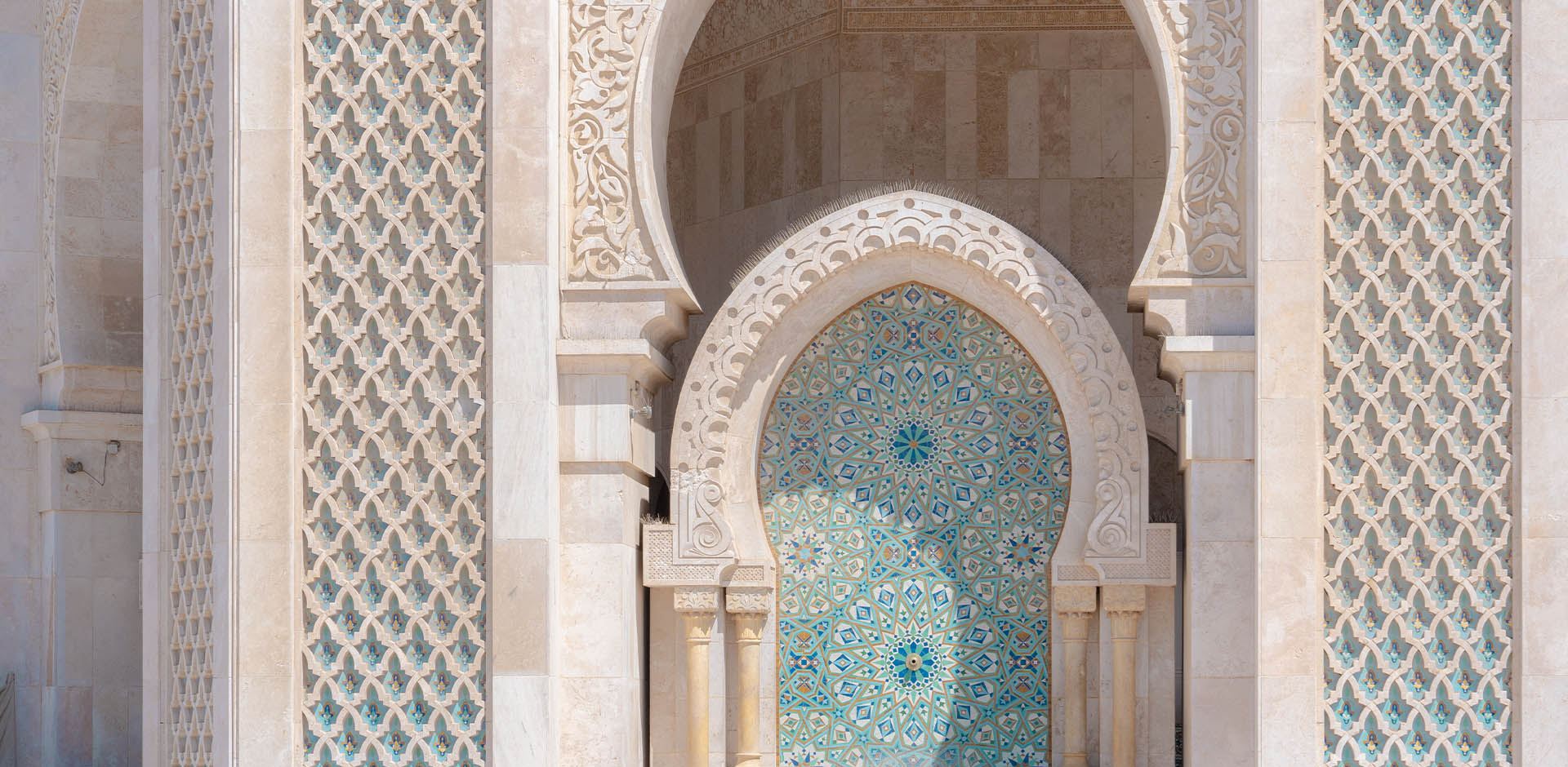 Architectural detail of turquoise tiles and ornate carved stone