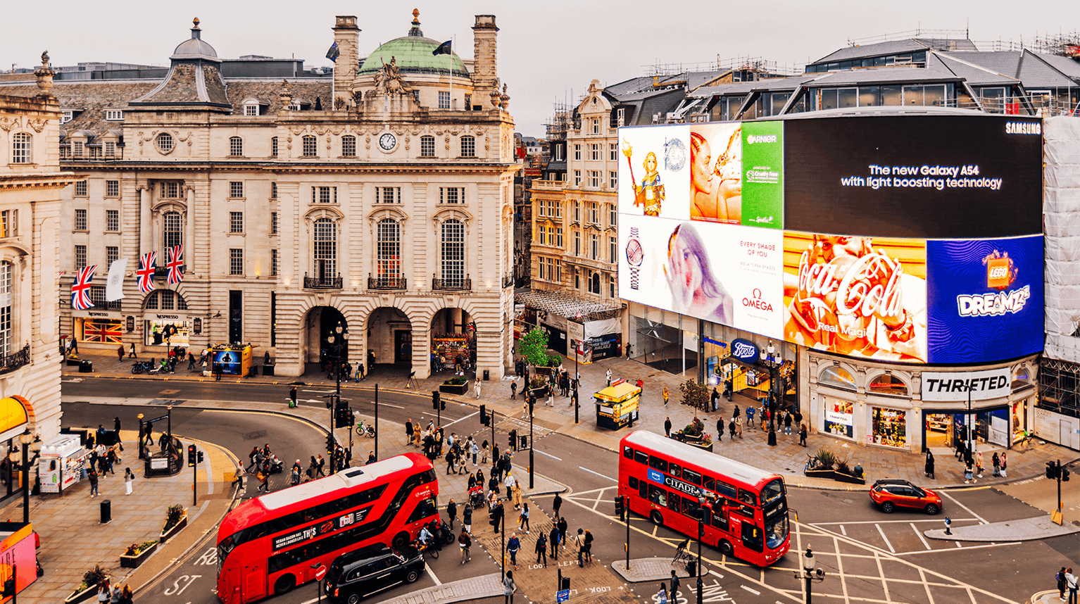 Double-decker buses driving through Piccadilly Circus