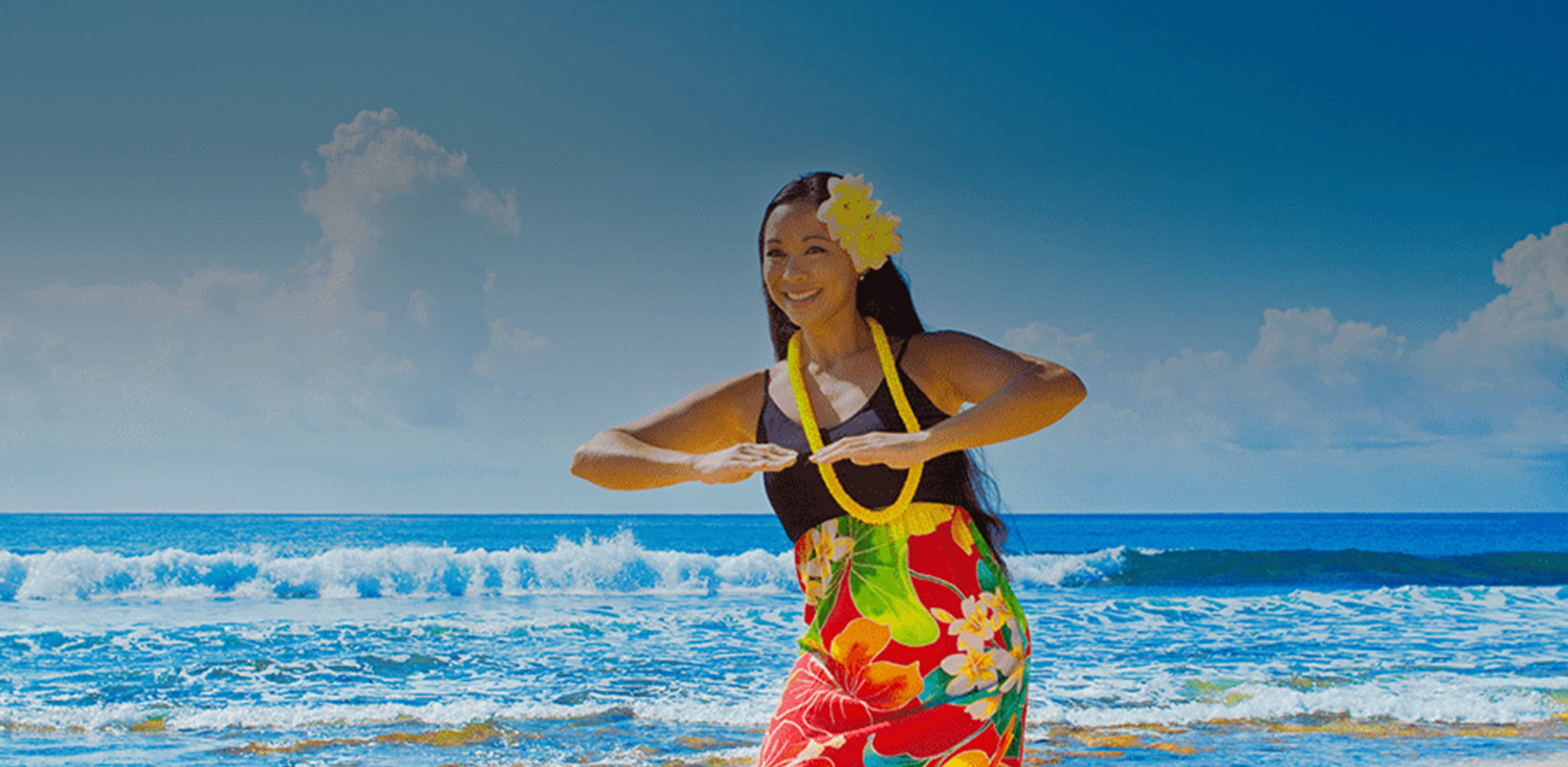 A woman dancing on a beach in a colourful more traditional outfit.