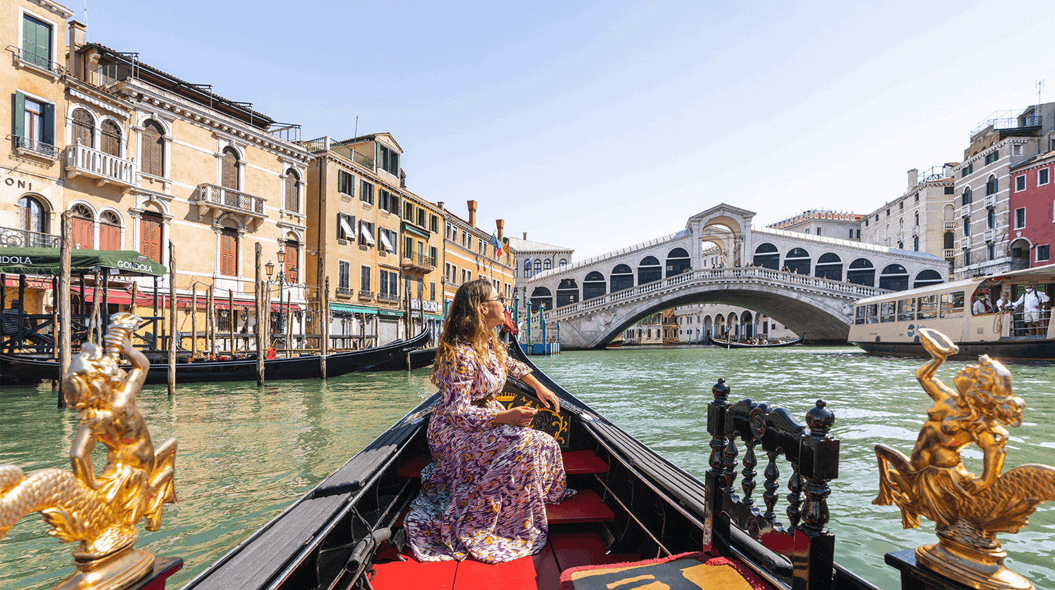 Female tourist on a gondola admiring the Rialto Bridge