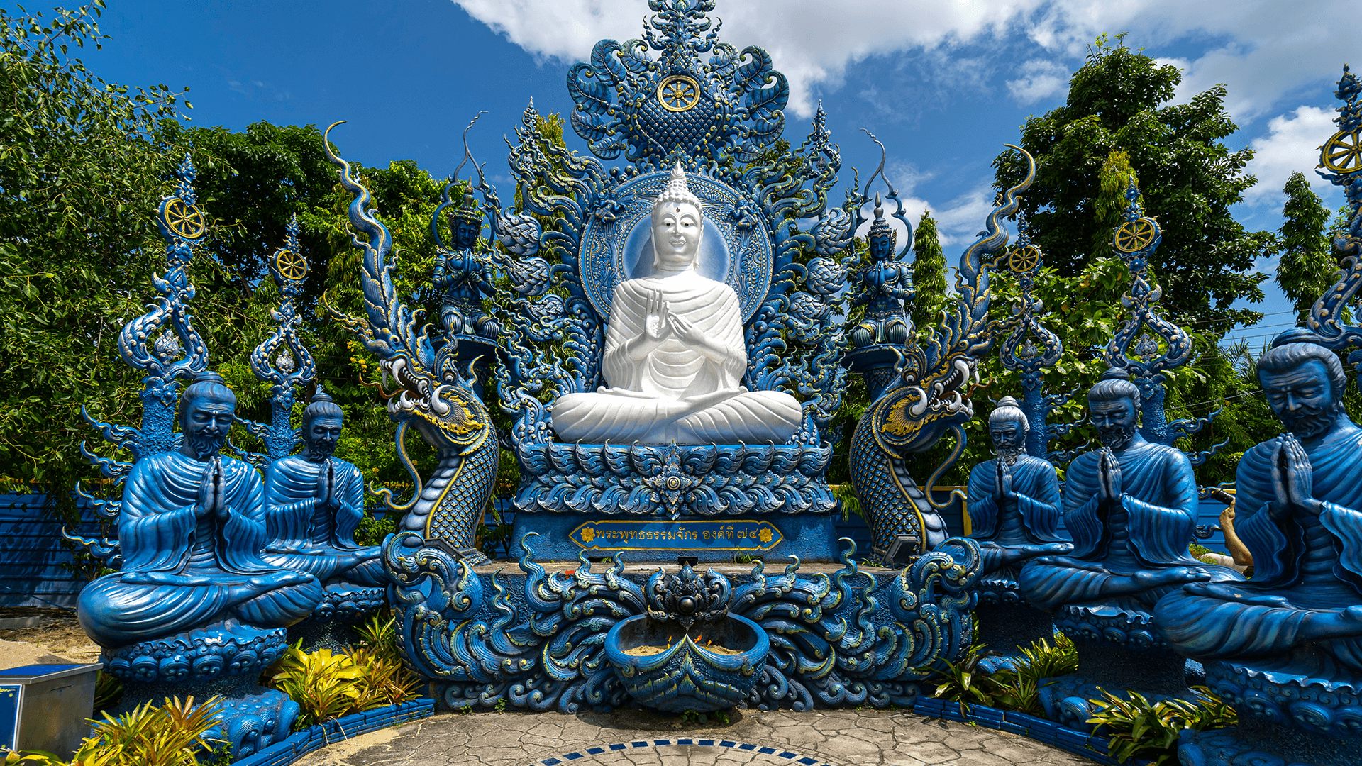 Blue temple statues surrounding a seated Buddha