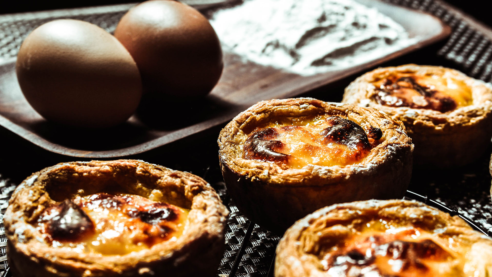 Close up of custard tarts cooling on a table