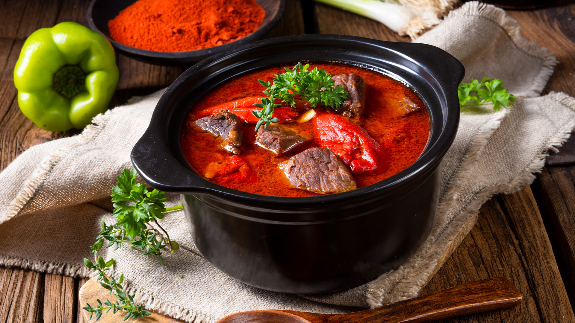 A pot of beef and paprika goulash on a kitchen table
