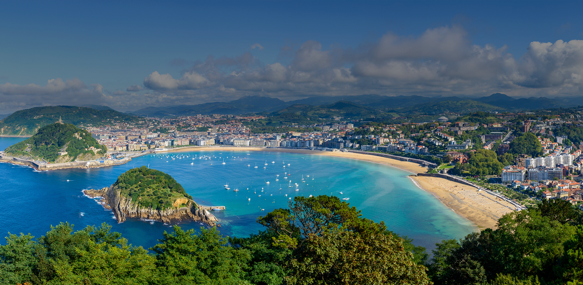 Aerial view of the bay, beach, city and surrounding mountains.
