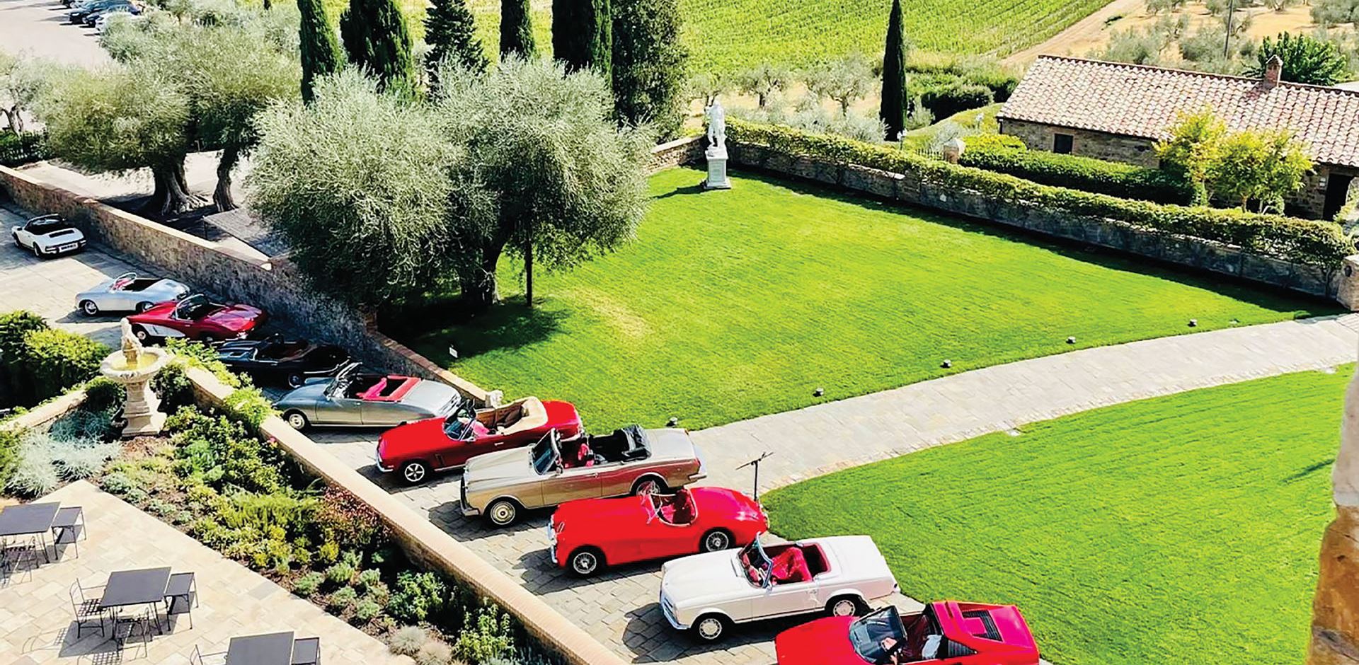 Lineup of classic cars on the grounds of a Tuscan estate