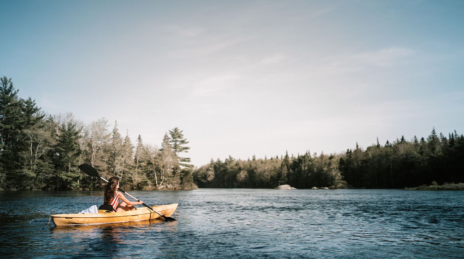 Woman kayaking at Trout Point Lodge, Nova Scotia