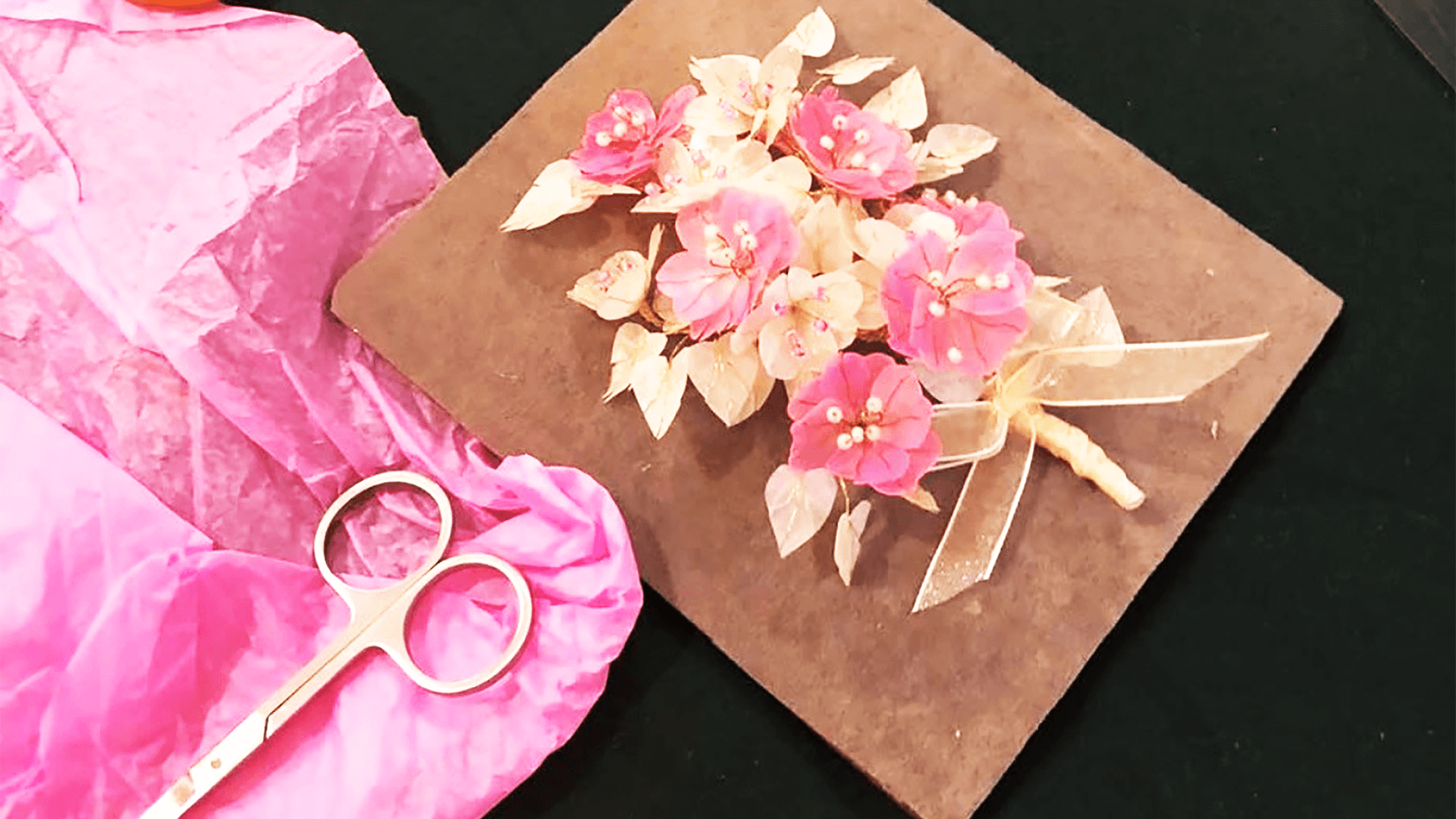 Scissors and tissue paper next to floral art