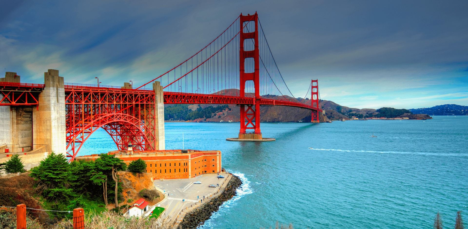 View of the Golden Gate Bridge over water and distant hills, San Francisco and Marin County near Sausalito, CA, US.