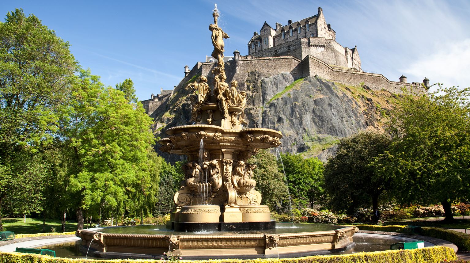 View of carved stone fountain with castle on hill behind