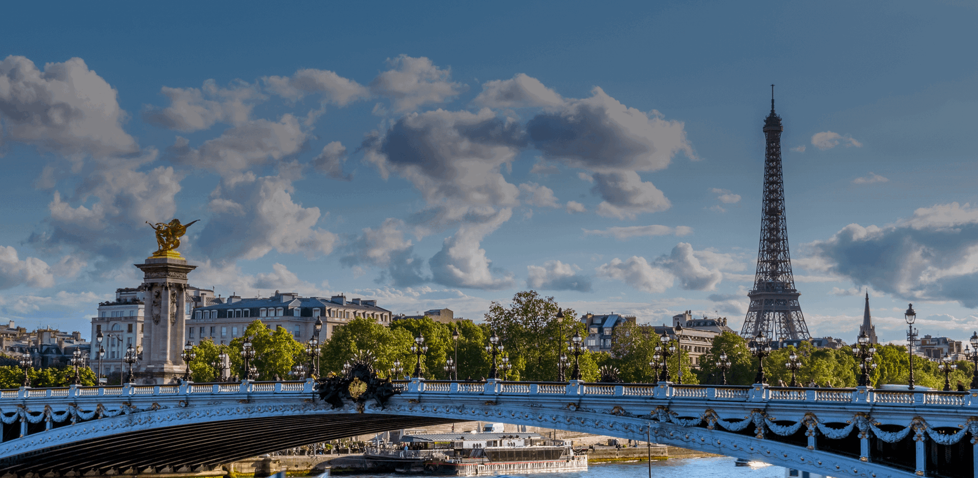 Bridge Over the Seine with a ferry on a sunny summer day with old building and the Eiffel Tower in the background, Paris, France.