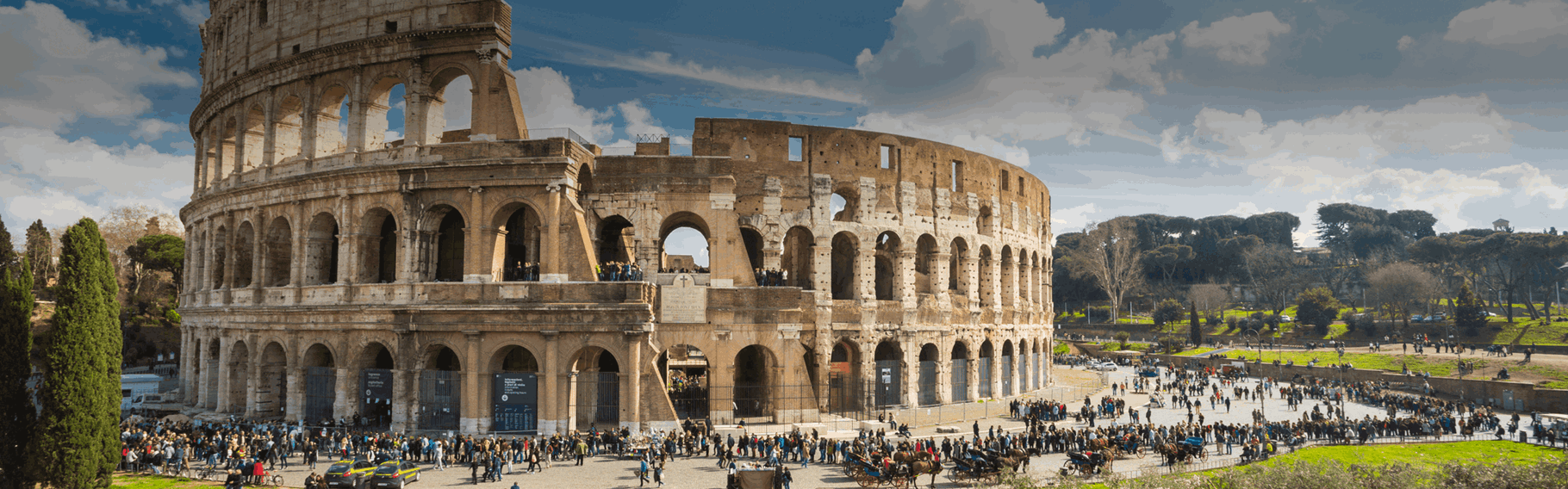 View of the Colosseum and the area around with many tourists walking and enjoying the day, Rome, Italy.