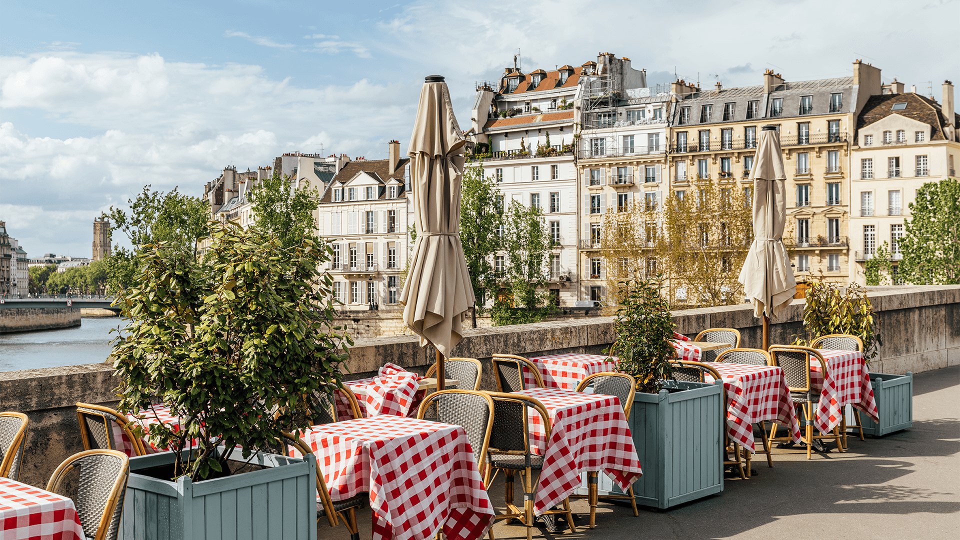 Outdoor café seating next to the Seine River in the sun