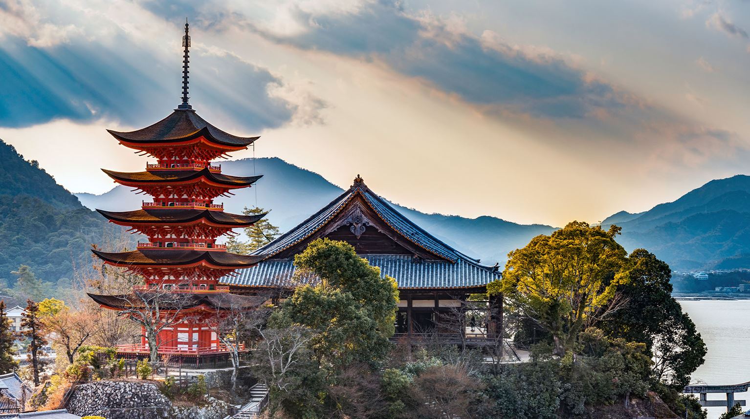 Red Shinto Pagoda surrounded by a dramatic cloudy sky
