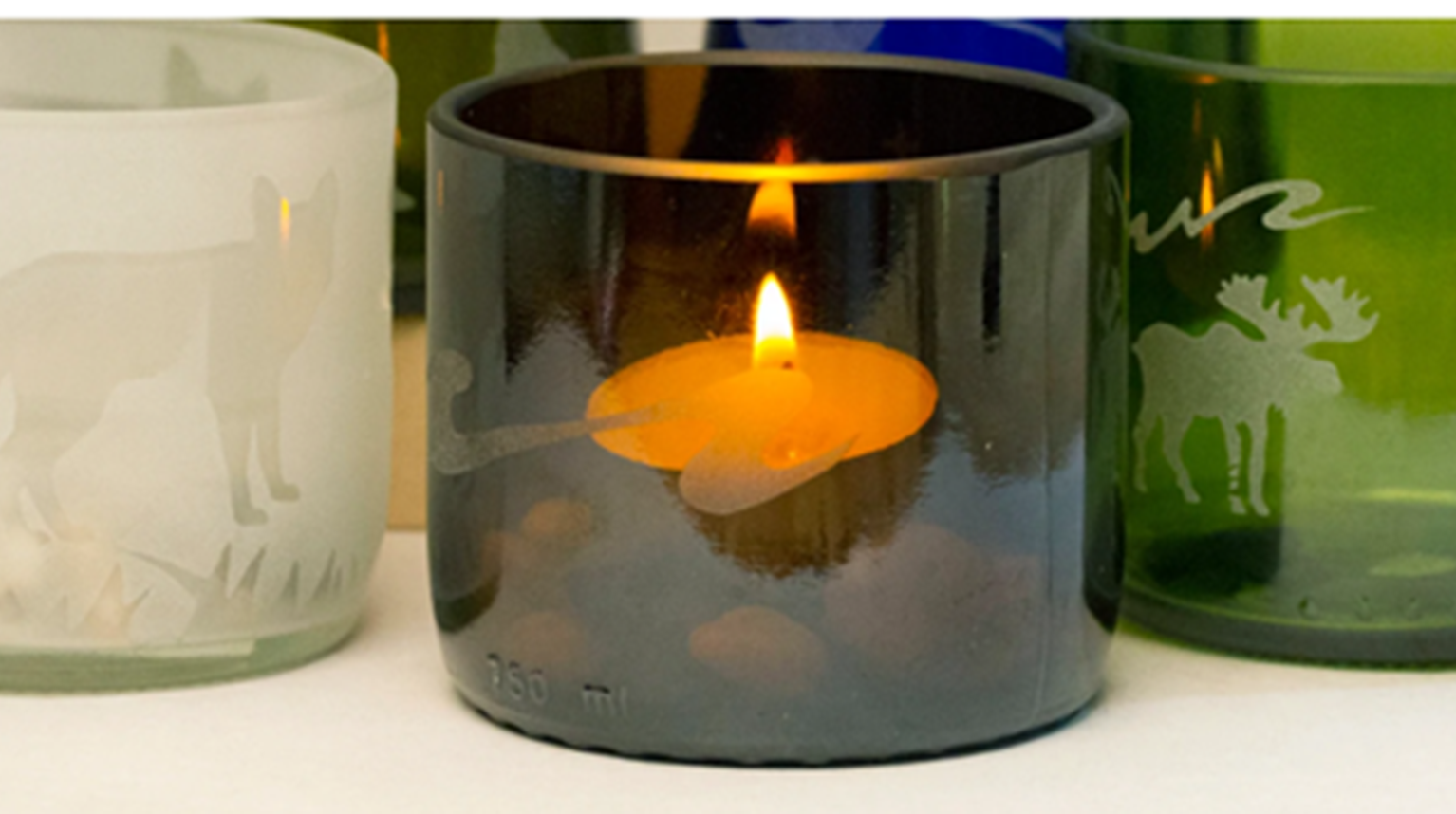 Three etched-candle glassware with one lit candle inside.