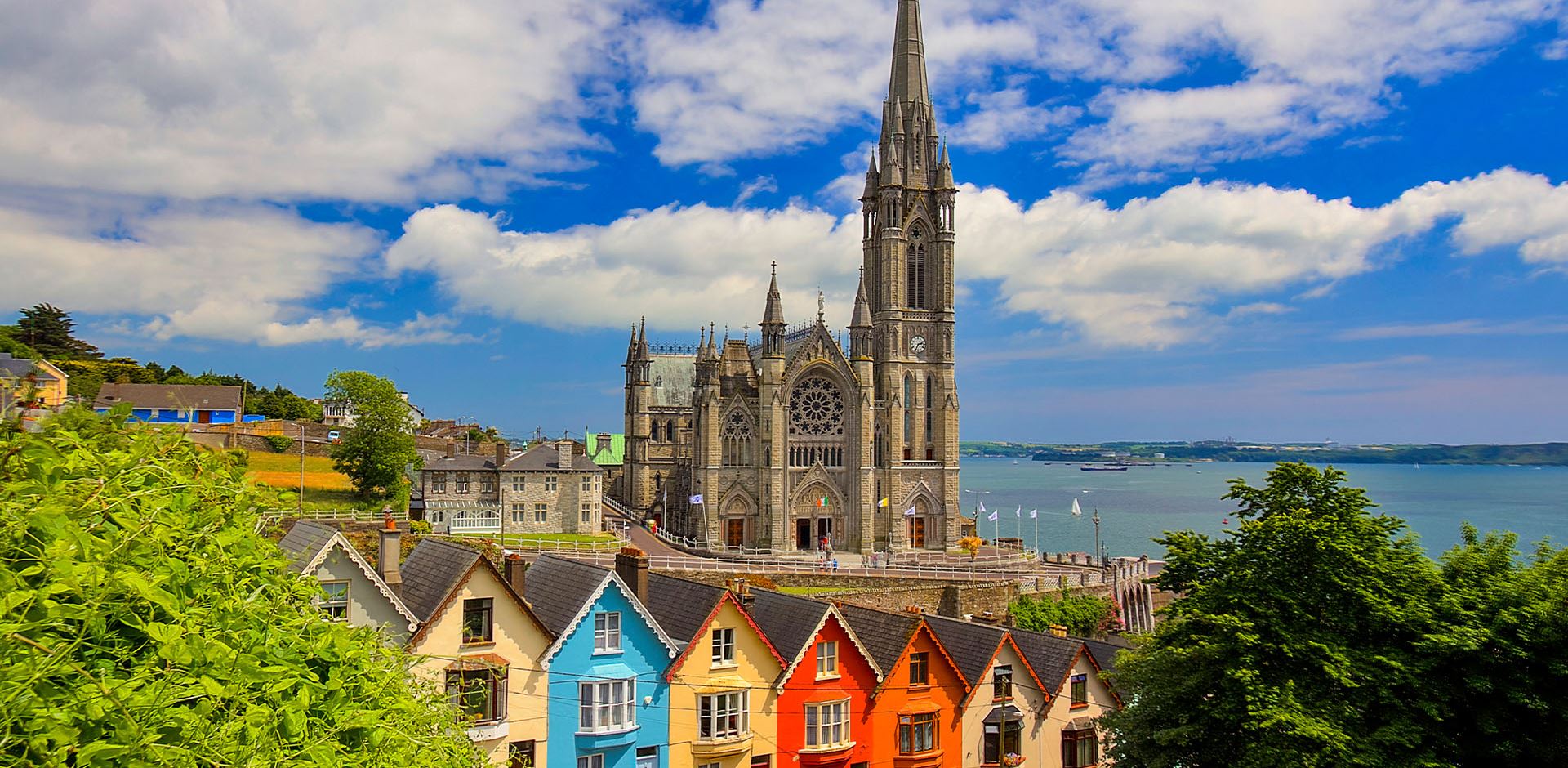 Row of colourful houses with cathedral in background